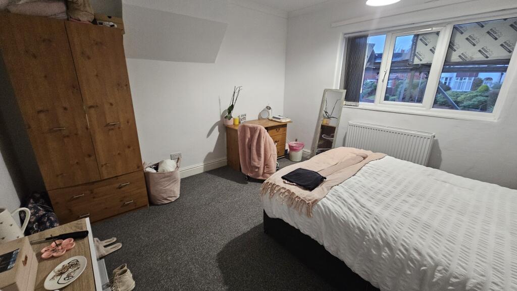 A cozy and neatly arranged double bedroom featu...