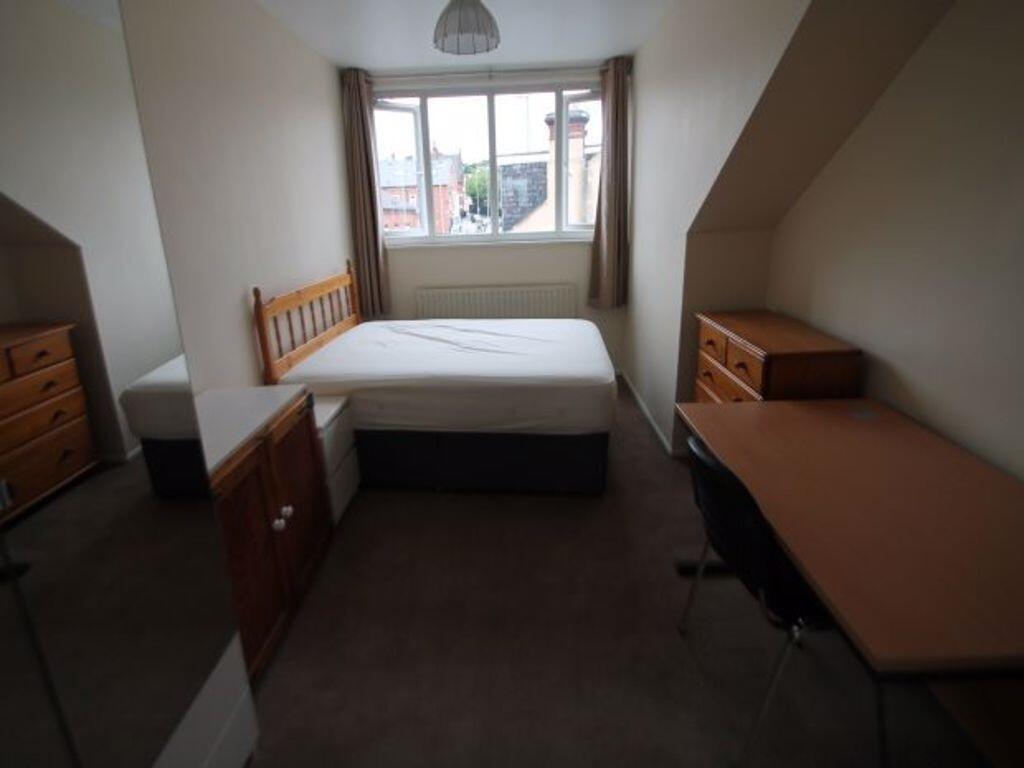 A cozy double bedroom featuring a large window ...