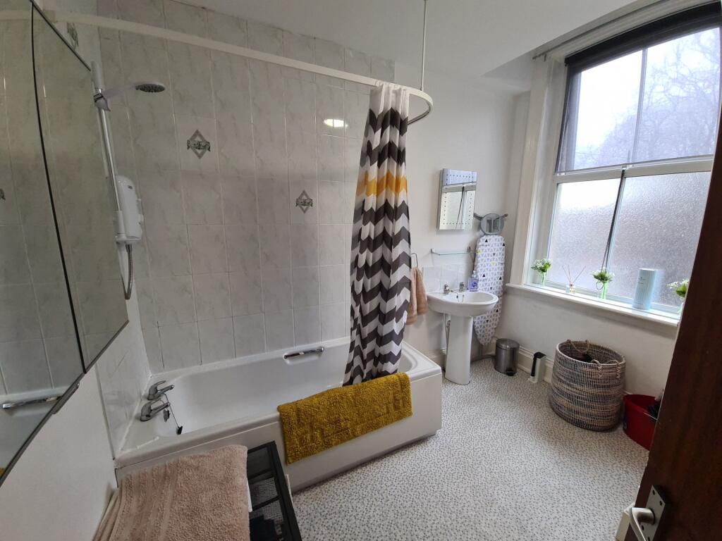 Bright, well-kept bathroom featuring a bathtub ...