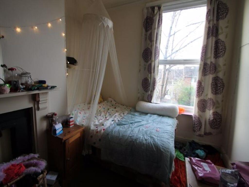 A cozy single bedroom featuring a comfortable b...