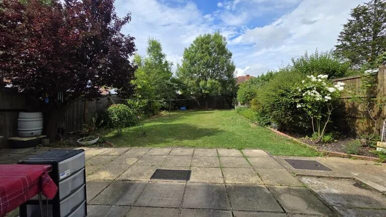 A spacious and well-maintained garden with a la...