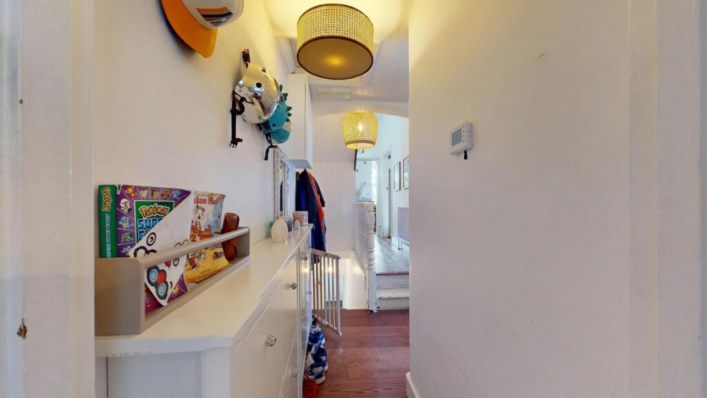 Bright and tidy hallway with white walls and wo...