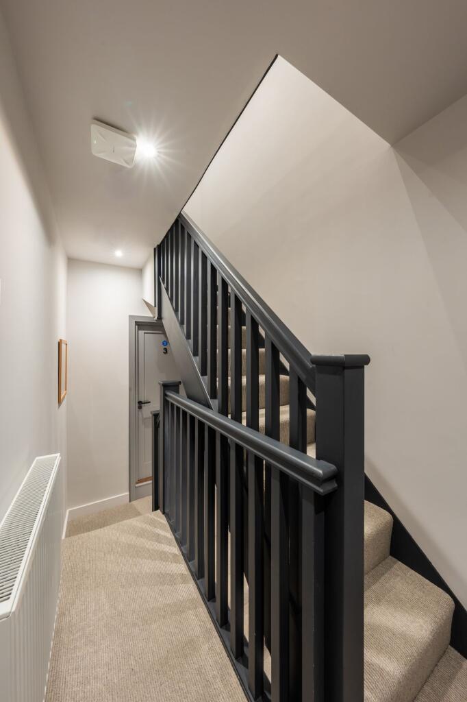 Well-maintained internal staircase with a dark-...