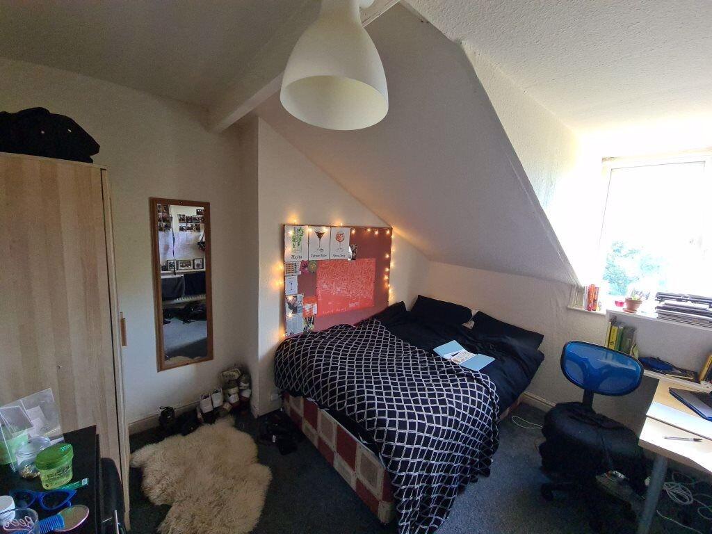 Cozy and well-lit master bedroom featuring a do...