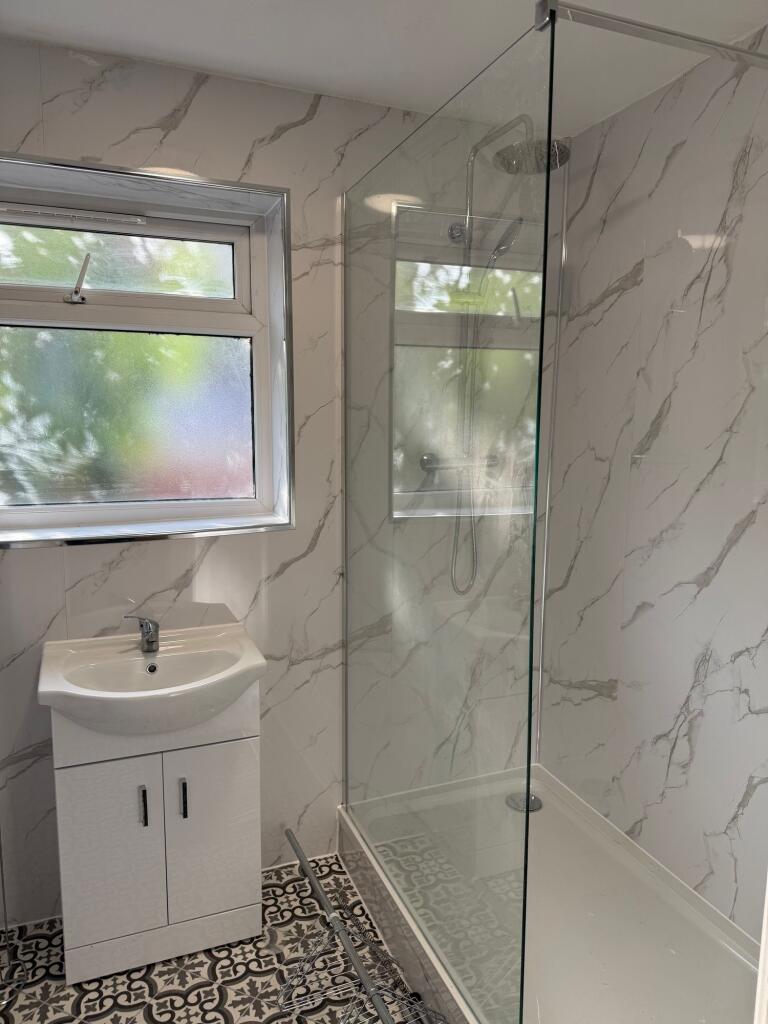 A modern bathroom featuring a walk-in shower wi...
