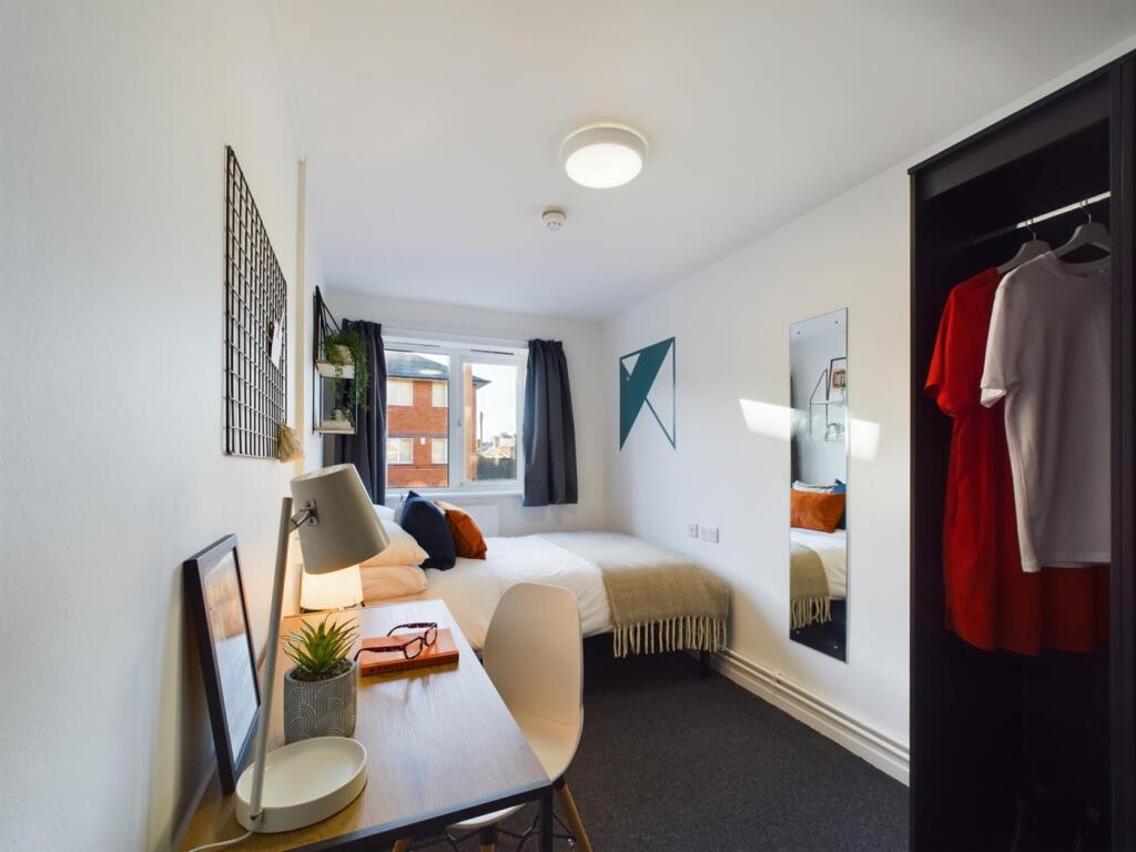 A bright and inviting double bedroom with styli...
