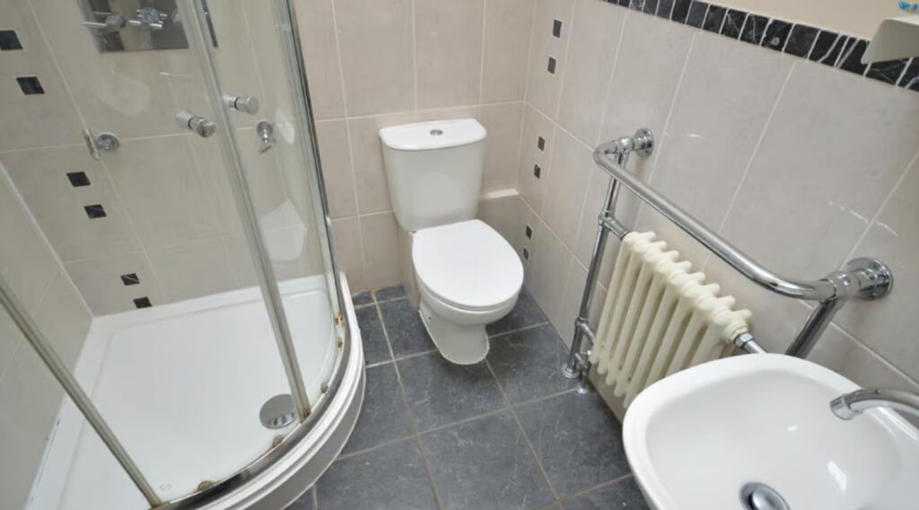 A modern bathroom featuring a sleek shower encl...