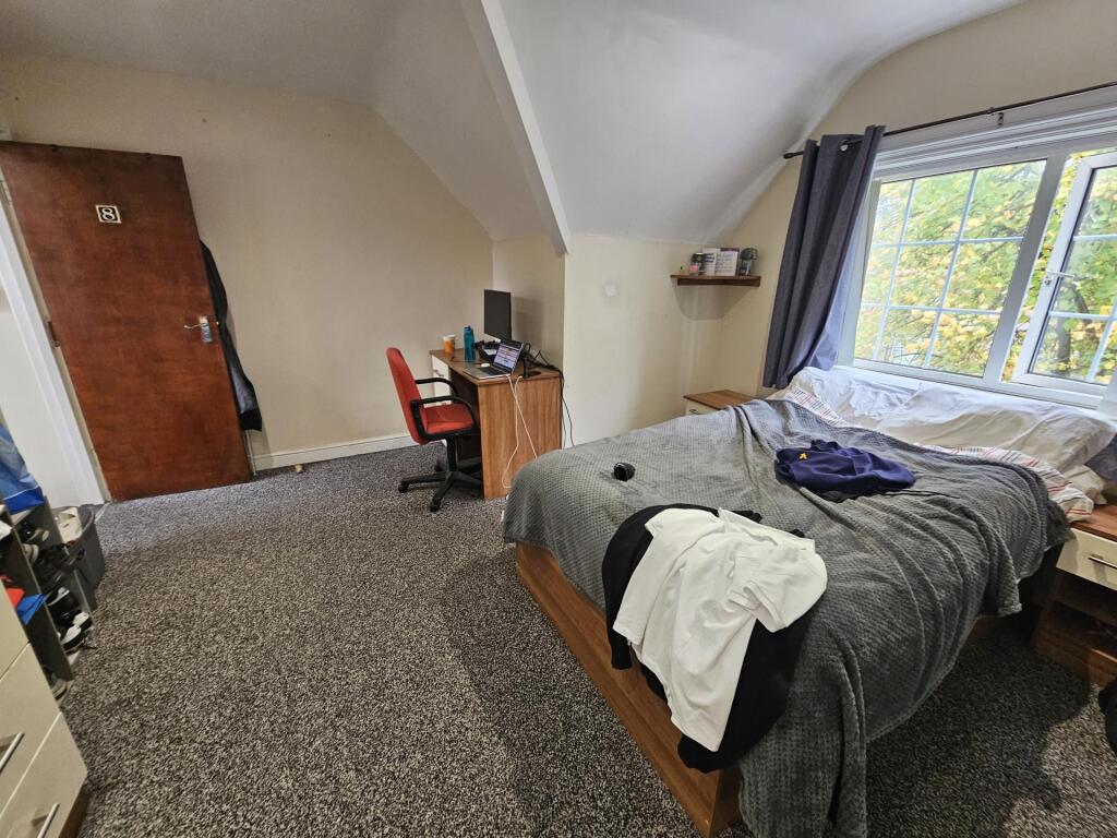 A cozy bedroom featuring a double bed with a be...