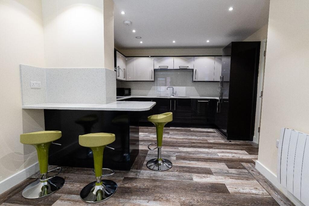 A modern kitchen featuring stylish black counte...