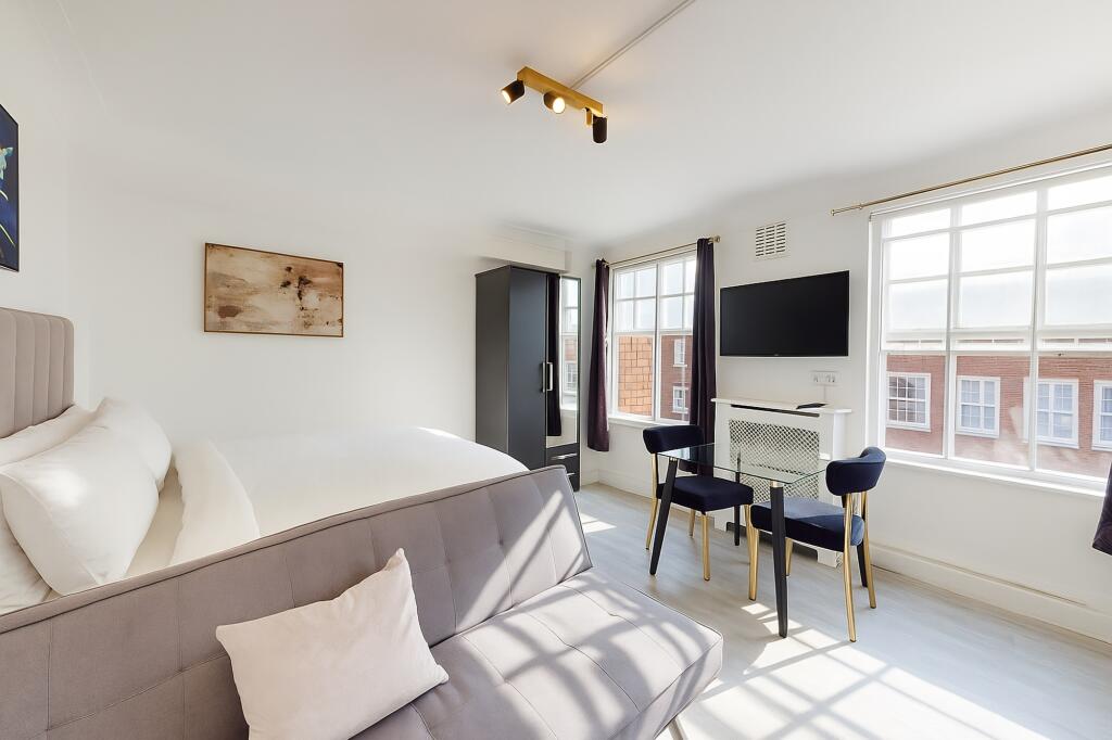 Bright and spacious living room featuring large...