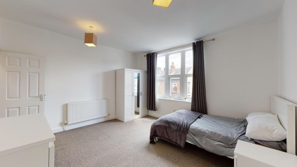 Bright and neatly arranged single bedroom featu...