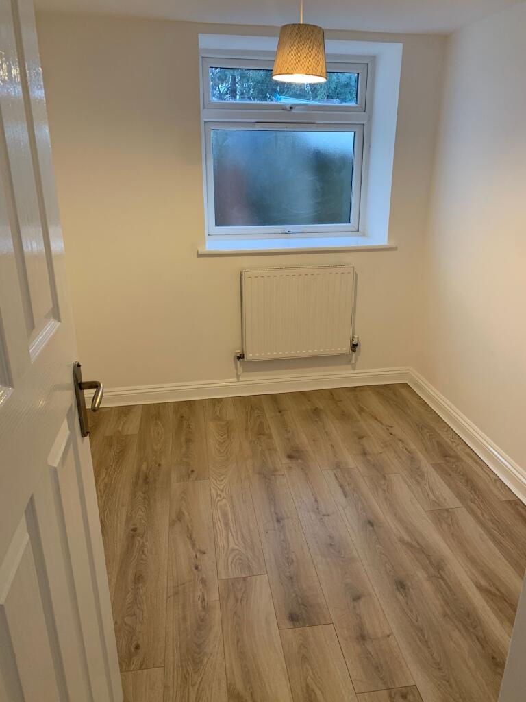 A clean and freshly painted small bedroom with ...