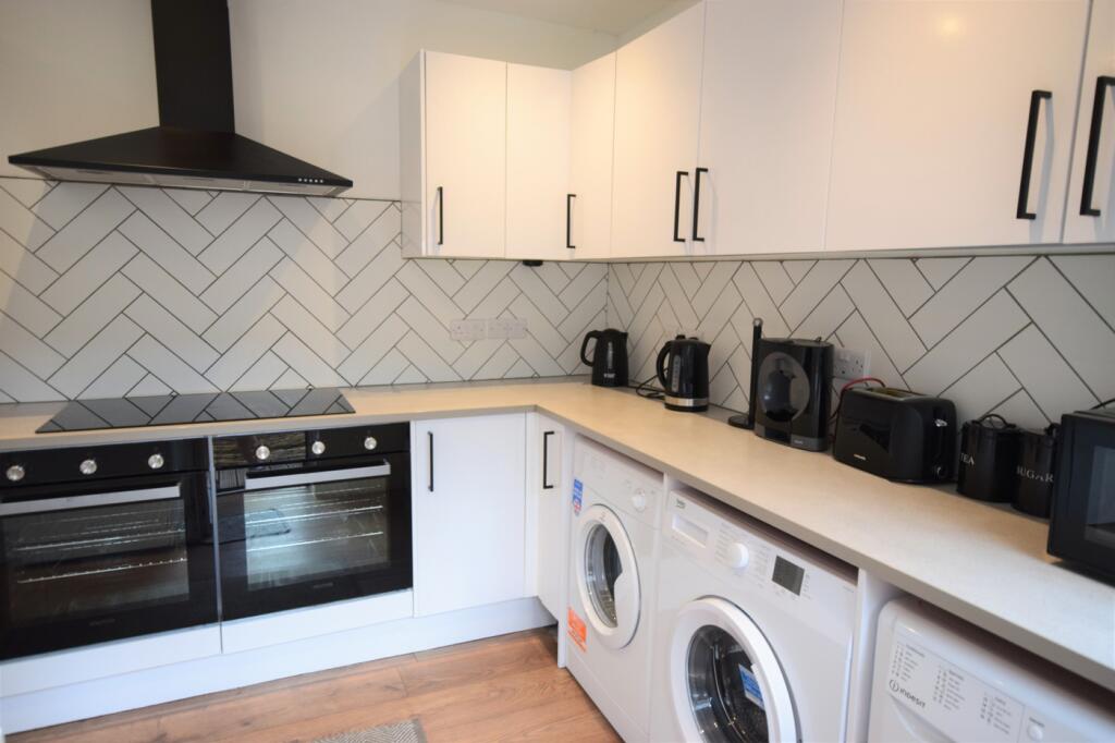 A modern and clean kitchenette with ample appli...