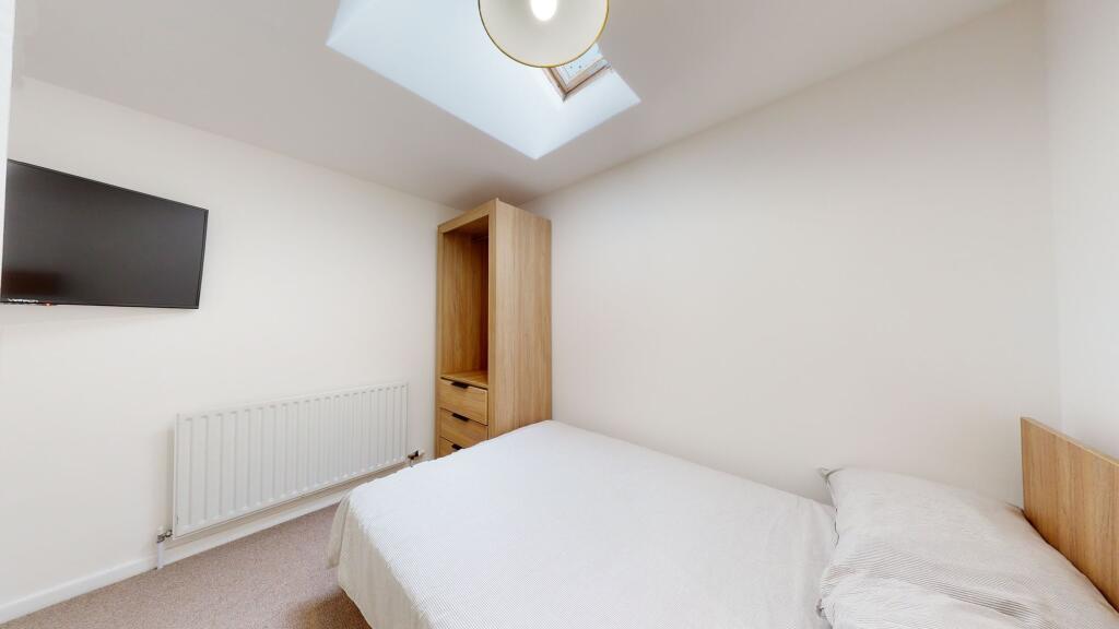 A bright and clean bedroom featuring a comforta...