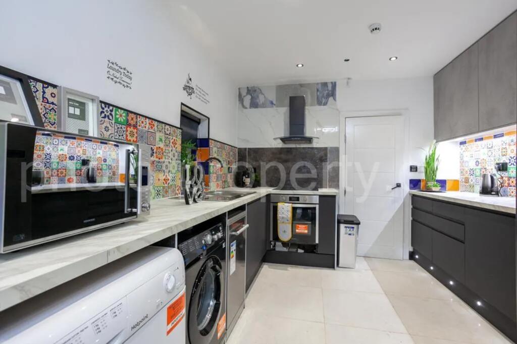 This stylish kitchen features vibrant tiled acc...