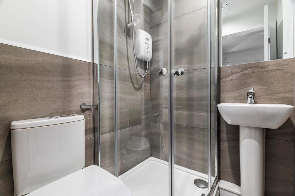 A clean and bright bathroom featuring a shower ...