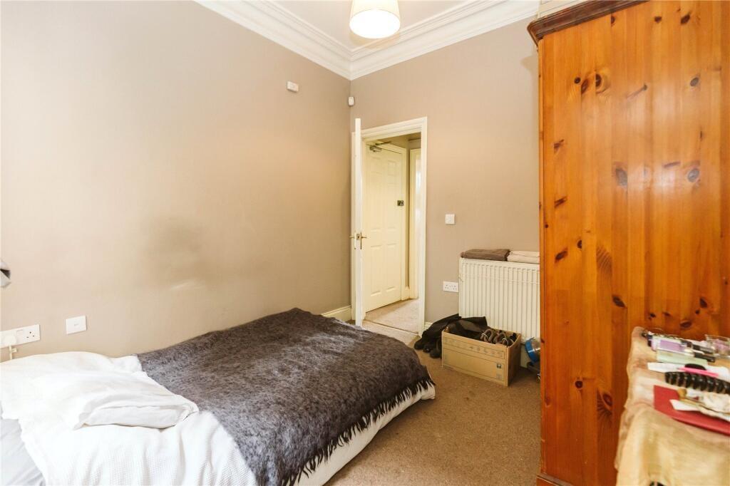 A cozy single bedroom featuring a comfortable b...
