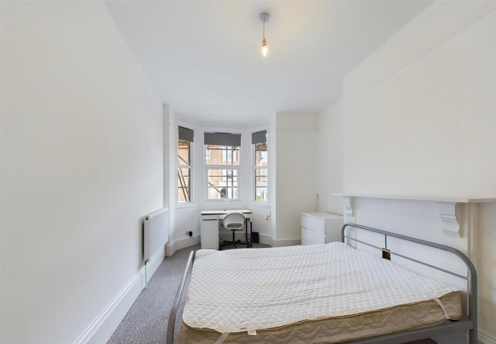 Bright and airy master bedroom featuring a larg...