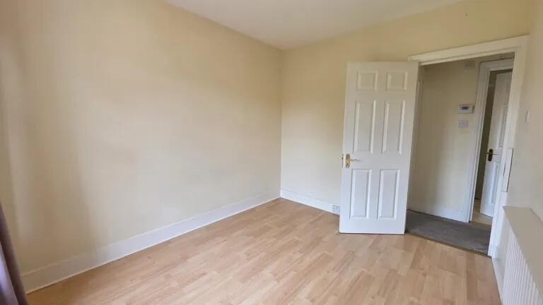 A bright, clean single bedroom with light woode...