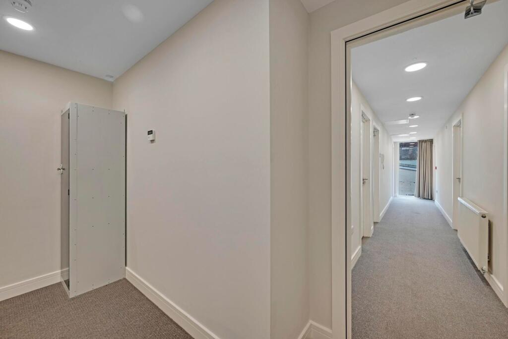 A clean, well-lit hallway with recessed ceiling...