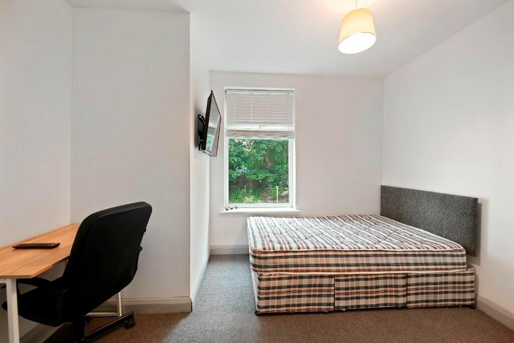 A bright and tidy double bedroom featuring a co...