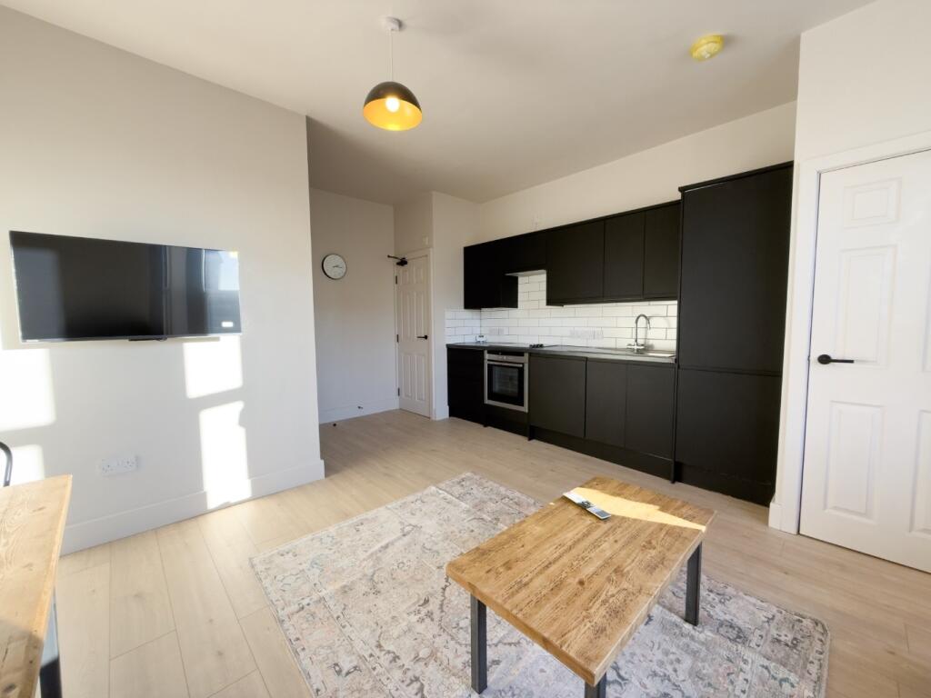 Bright open-plan kitchen-living space with mode...