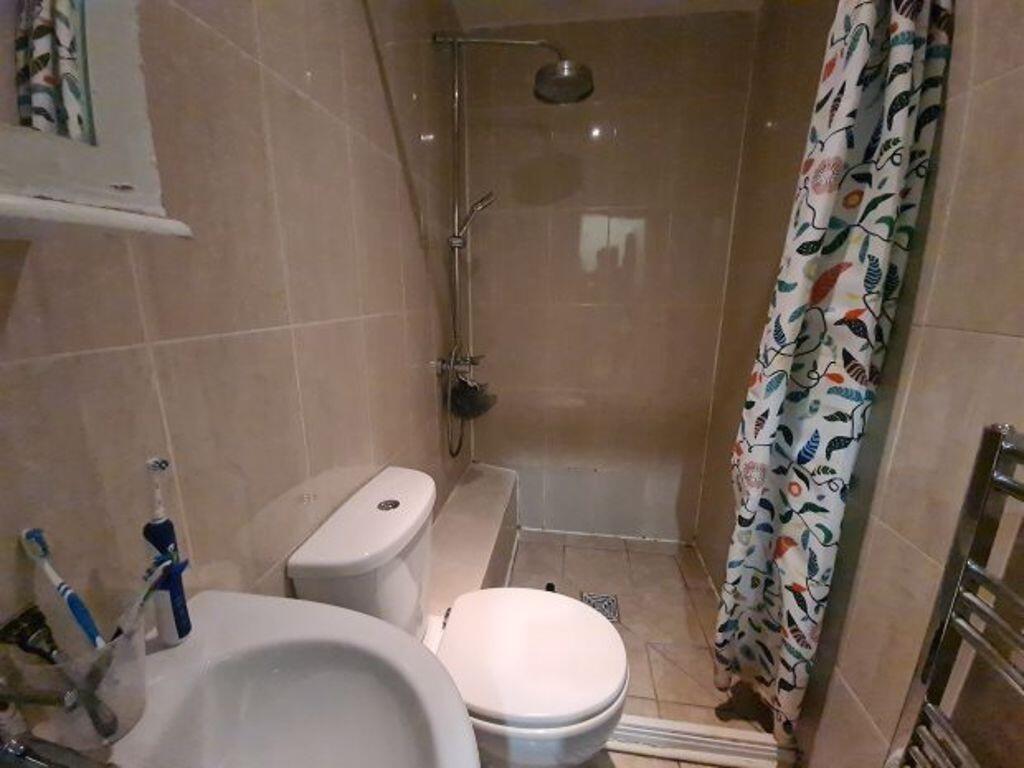 Well-kept bathroom with a tiled bath/shower, wh...