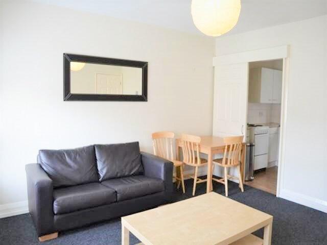 A bright and tidy living room featuring a comfo...