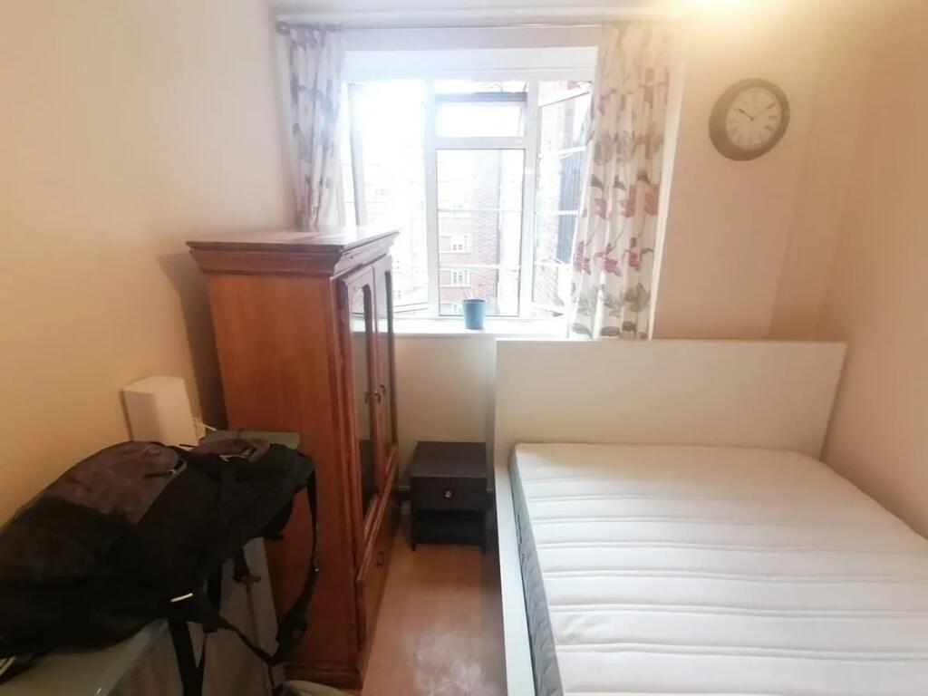 A cozy bedroom featuring a single bed with a wh...