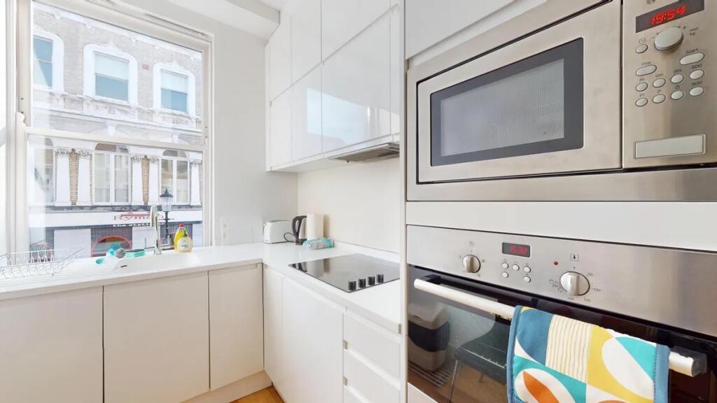 Bright and modern kitchen featuring sleek white...