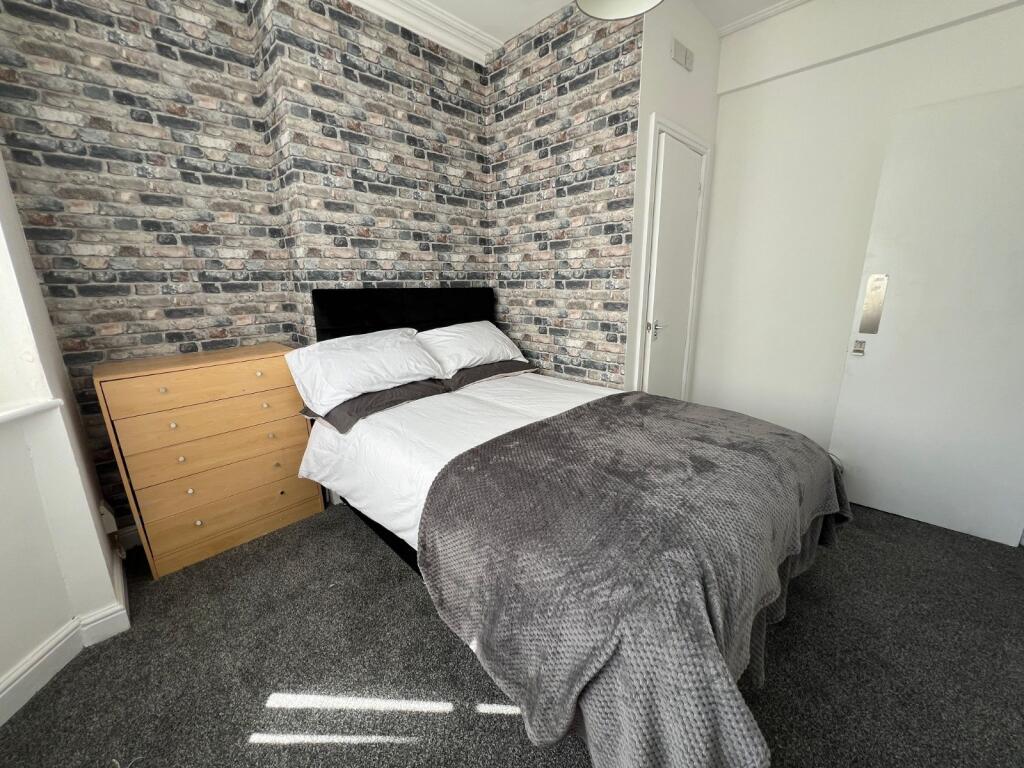 A stylish double bedroom featuring a cozy bed w...
