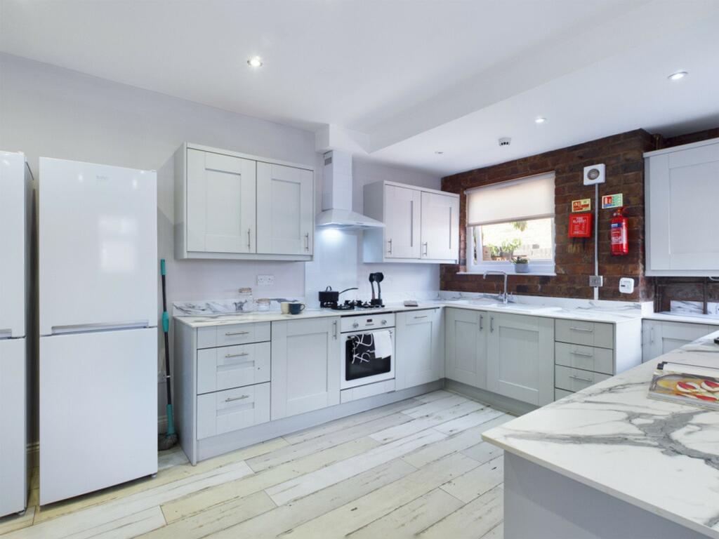 A bright and modern kitchen featuring sleek cab...