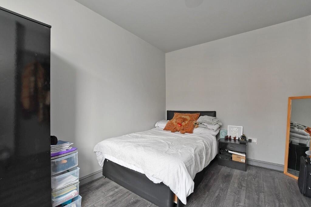 A neat and cozy single bedroom featuring a comf...