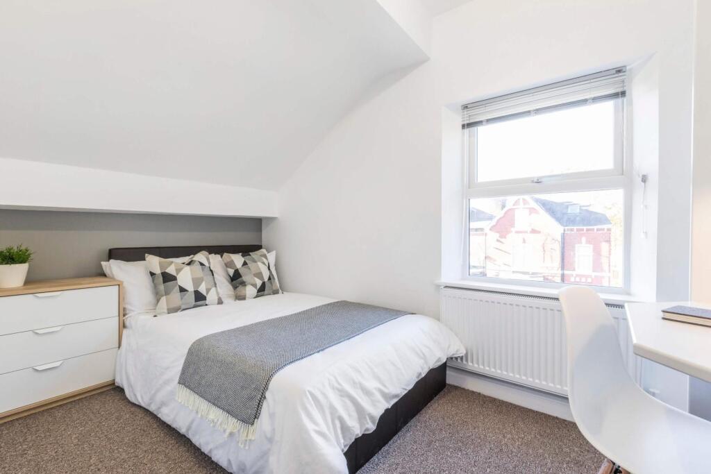 A bright, tidy bedroom featuring a double bed w...