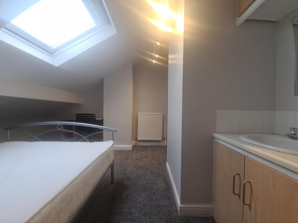 A cozy attic bedroom featuring a skylight that ...