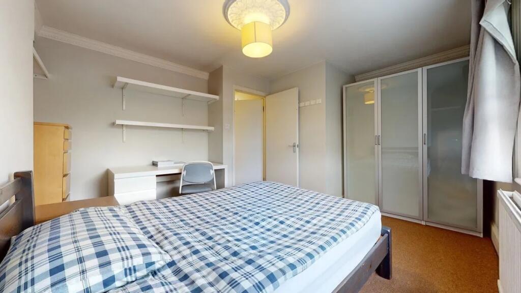 A bright and tidy double bedroom featuring a co...