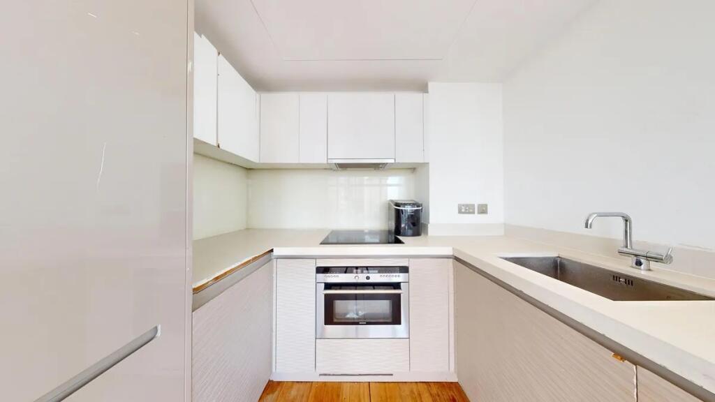 Bright and modern kitchen featuring sleek white...