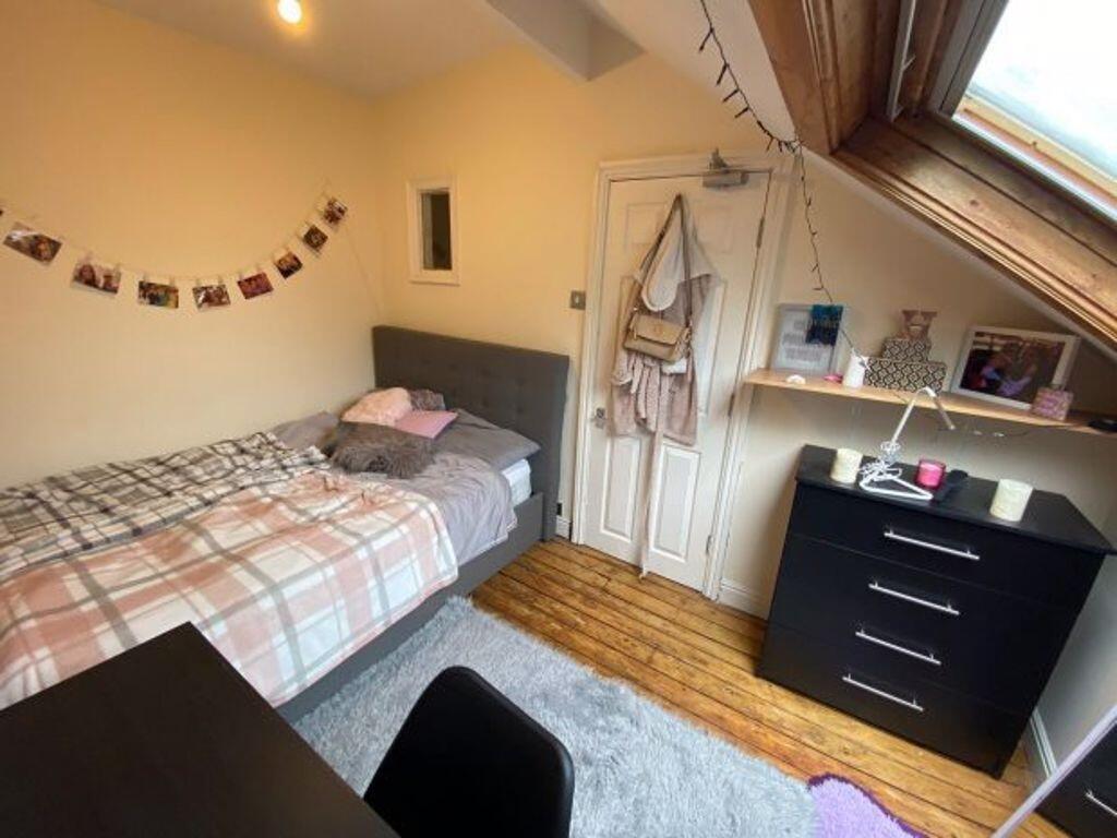 A cozy single bedroom featuring a neatly made s...