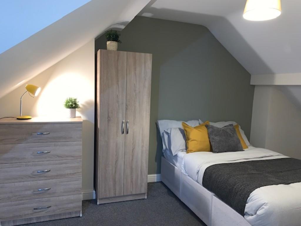 A cozy and well-kept single bedroom featuring a...