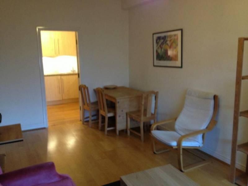 A cozy living room featuring a wooden dining ta...