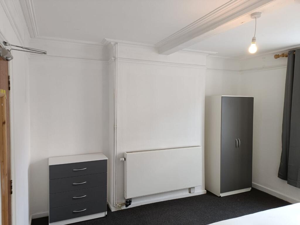 A neat and simple room featuring white walls, a...