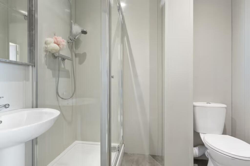 A modern and immaculate bathroom featuring a sp...