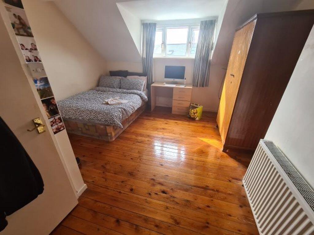A cozy bedroom featuring a single bed, a wardro...