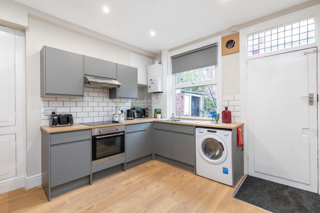 Bright, modern kitchen with grey cabinetry, woo...