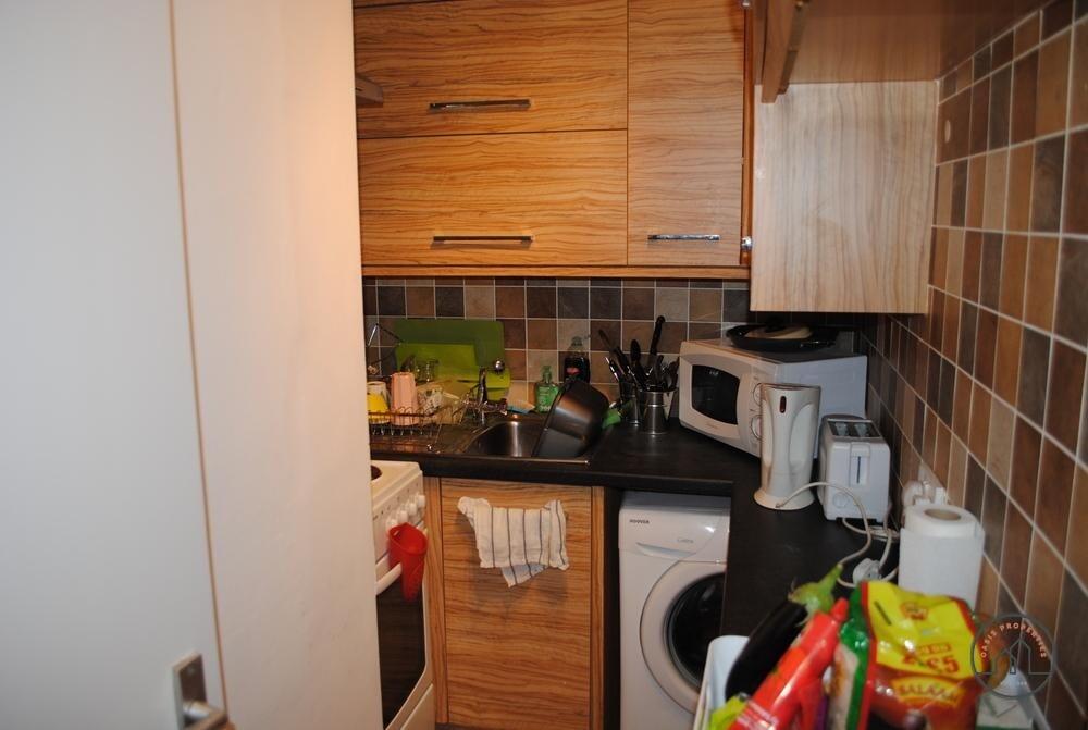 A cozy kitchen area featuring wooden cabinetry,...