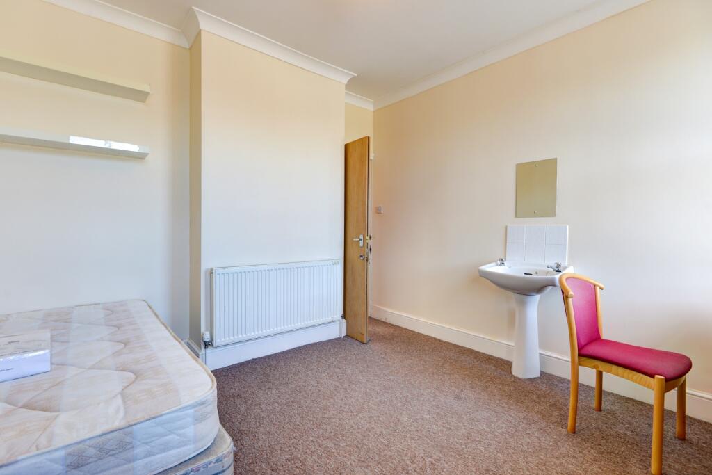 A simple and tidy single bedroom featuring a be...