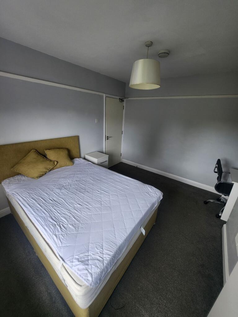 A neat double bedroom featuring a comfortable b...