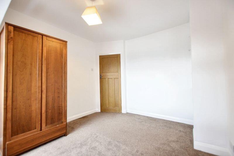 A clean and bright single bedroom featuring a w...