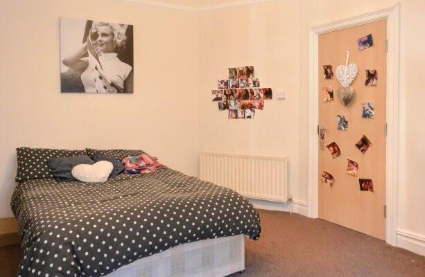 A cozy double bedroom featuring a large bed wit...