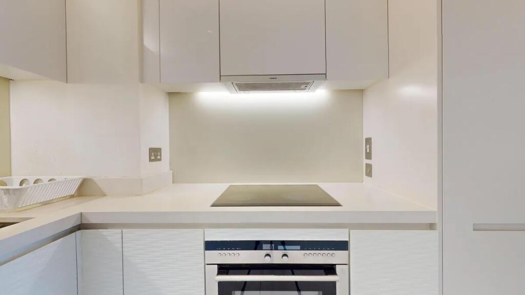 A sleek, modern kitchen featuring clean white c...